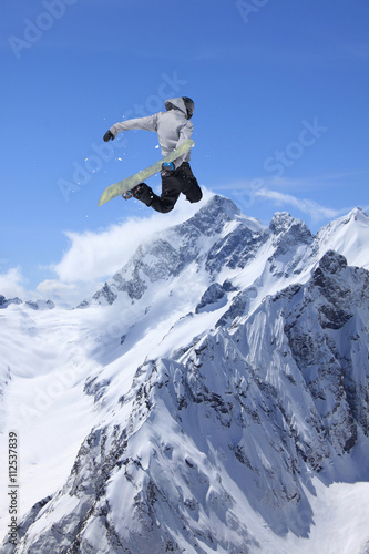 Cuadros en Lienzo Corredor de snowboard que salta sobre las montañas