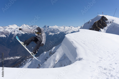 Cuadros en Lienzo Corredor de snowboard que salta sobre las montañas