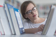 © .shock - portrait of famale student selecting book to read in library