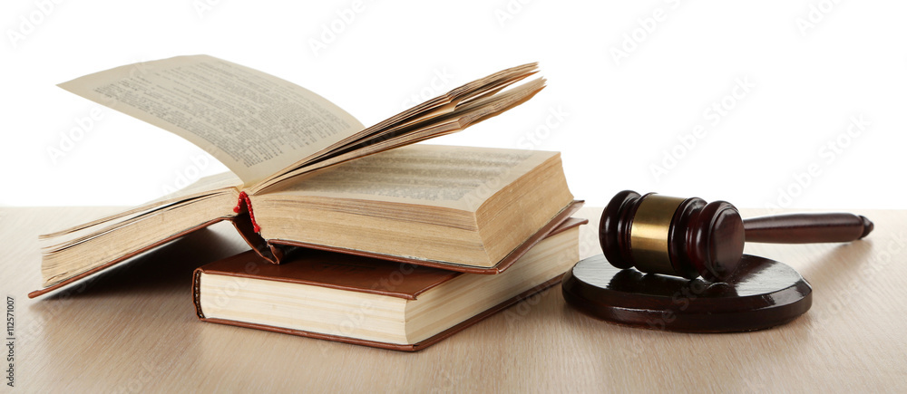 Gavel and books on wooden table on white background