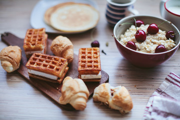 rich breakfast of porridge with cherries and pastry