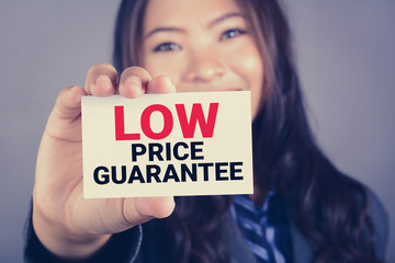 LOW PRICE GUARANTEE message on the card shown by a woman