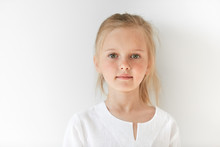 Portrait Of Angel-like Child In White Morning Light In Studio. Little European Girl With Blond Hair Looking Attractive And Balanced Showing Neutral Emotions And Radiating Tranquility.