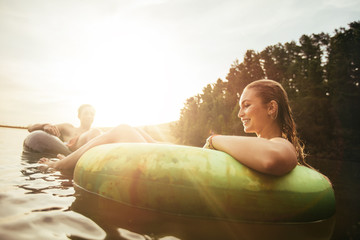 Young woman floating in an innertube at sunset