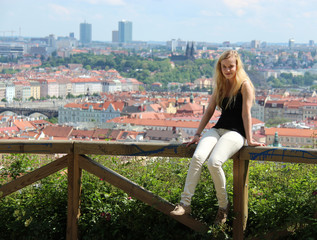 Beautiful blond girl looking to you (background of town - Prague)