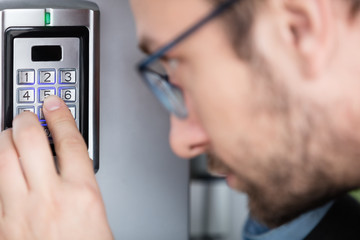 Wall Mural - Close up of a man entering security code combination to unlock the door   