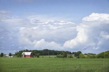 Wall Mural - Red barn and field below dramatic cloudscape