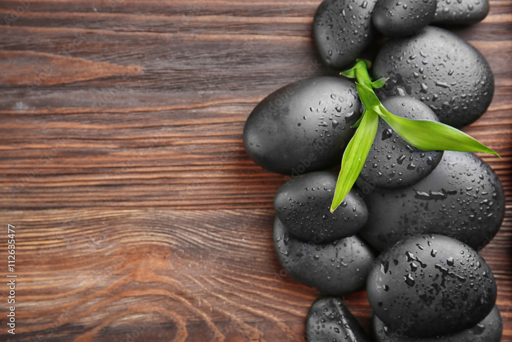 Black stones for therapy on wooden background