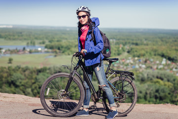 Beautiful sensuality elegance traveler woman cyclist, has happy fun cheerful smiling face, ripped blue jeans. Has slim sport body.