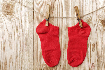 Colorful socks hanging on the clothesline on old wooden backgrou