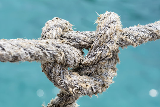Rope with marine knot on a sea water background