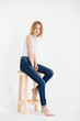 © sergeyzapotylok - Young European woman posing in studio for test photo shoot showing different poses sitting on bar stool