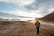 © Anna Jones Photo - Rear view of man walking geothermal site