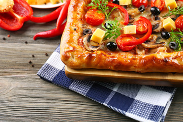 Freshly homemade pizza on wooden table closeup