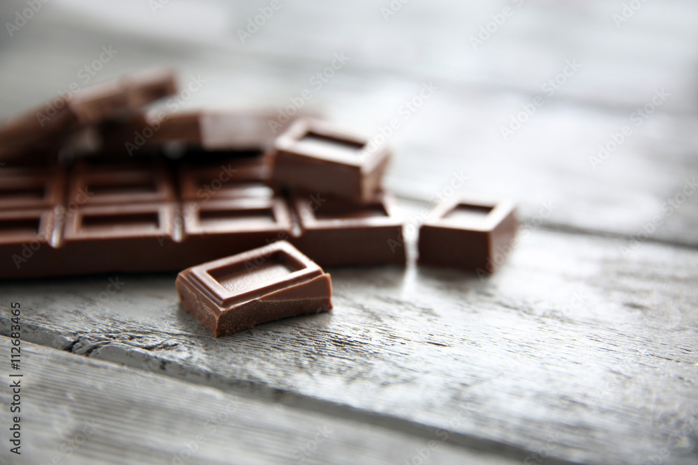 Chocolate pieces on wooden background