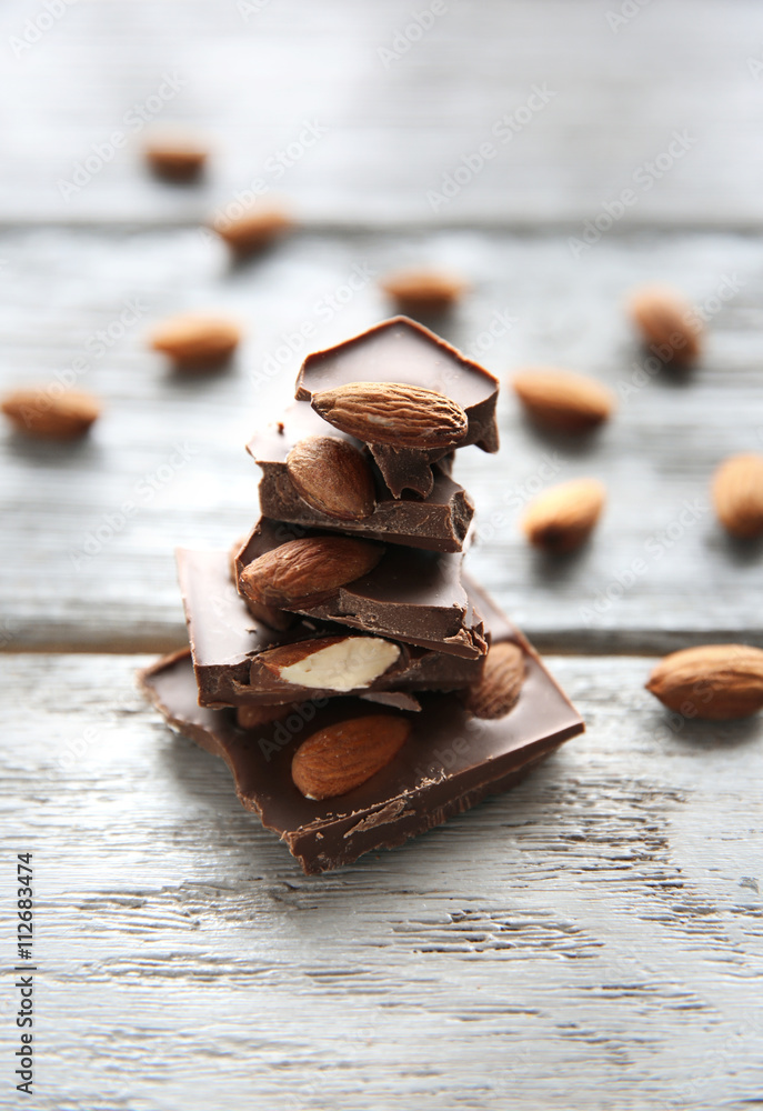 Chocolate pieces with nuts on wooden background