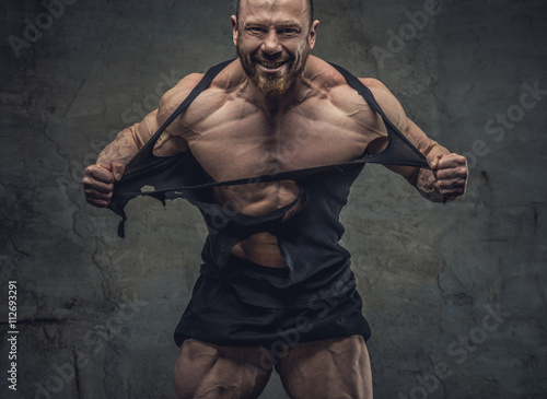 Fényképezés  Huge bodybuilder rend his garments.