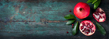Fresh Juicy Pomegranate - Whole And Cut, With Leaves On A Wooden Vintage Background, Top View, Horizontal, With Copy Space