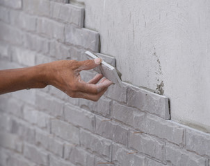 worker install stone wall tile with cement for house