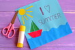 Paper card with ship, sun, sea. I love summer. Kids summer camp idea for crafts and activity. Inspiration for children of all ages. Paper art children project. Scissors, glue stick. Wooden background