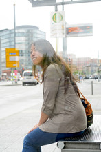 Deutschland, Berlin, Junge Frau Wartet An Der Bushaltestelle, To