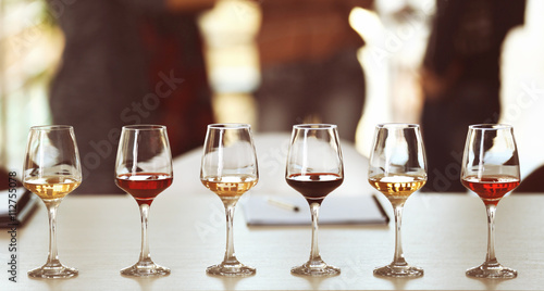 Fotografía Many glasses of different wine in a row on a table