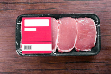 Poster - Packed pieces of pork meat on wooden background