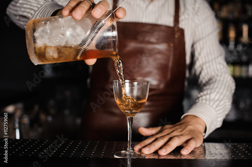 barman pouring alcoholic cocktail in glass Canvas Print