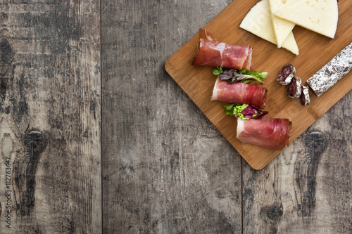 Foto Spanish serrano ham, cheese and sausage on a rustic wooden background