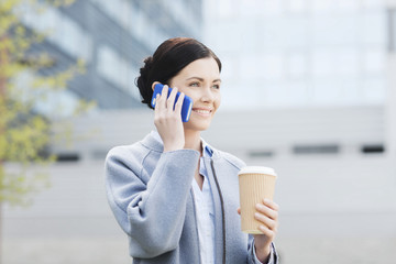 Canvas Print - smiling woman with coffee calling on smartphone