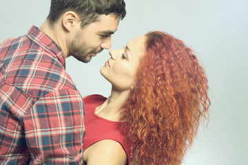 Wall Mural - Happy young couple in love embracing on grey background, close up