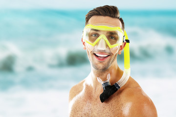 Wall Mural - Young man with swimming mask or goggles on blurred sea background