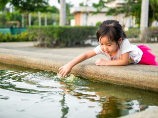  Beautiful young girl child fing something in the pool