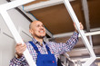 © caftor - smiling man holding a window frame