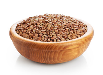 Wooden bowl with lentils isolated on white background.