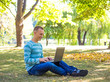 © lkoimages - Student using his laptop in autumn city park