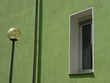 Straßenbeleuchtung vor einer grünen sanierten Fassade mit Rauputz und Fenster bei Sonnenschein in Bielefeld im Teutoburger Wald in Ostwestfalen-Lippe