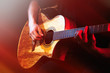 © Africa Studio - Young man playing on acoustic guitar on dark background with light effect
