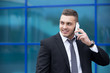 © fizkes - Portrait of happy business man on smartphone. Copy space