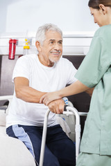 Canvas Print - Nurse Assisting Patient To Stand In Rehab Center