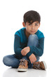 © mmilliman - Full length portrait of a young mixed race boy sitting on the floor. Isolated on white.