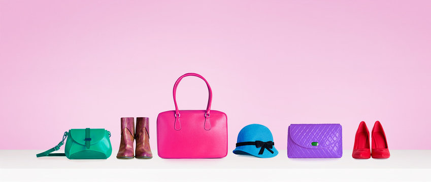Colorful hand bags,purse,shoes, and hat isolated on pink background. Woman fashion accessories items. Shopping image. 