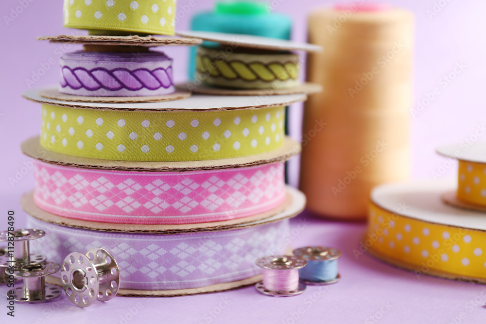 Spools of color ribbons on purple background