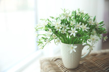 Bouquet Of Little White Flowers On Wicker Furniture