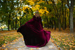 Beautiful girl with lantern in the scary autumn wood. Fantasy and Halloween image. Costumed woman in the park outside.