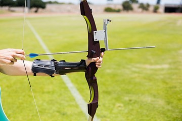 Wall Mural - Female athlete practicing archery