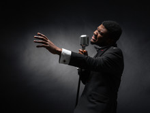 Afro Amerian Man Singing Into Vintage Microphone