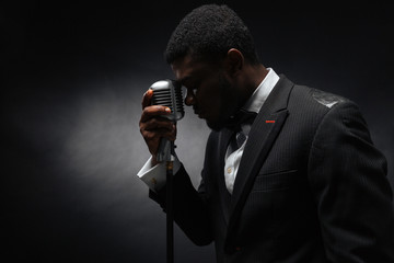 Wall Mural - Afro amerian man singing into vintage microphone