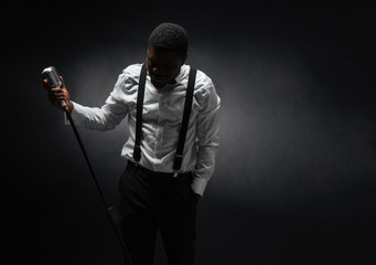 Wall Mural - Male singer posing over dark background