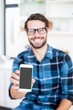 © WavebreakmediaMicro - Cute hipster with glasses showing smartphone screen